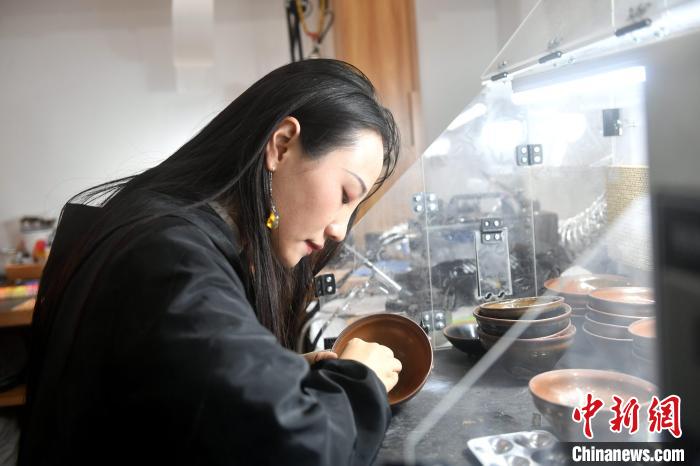 在唐潔工坊內(nèi)，“90后”文物修復師瞿汕正低頭忙碌?！蚊?攝